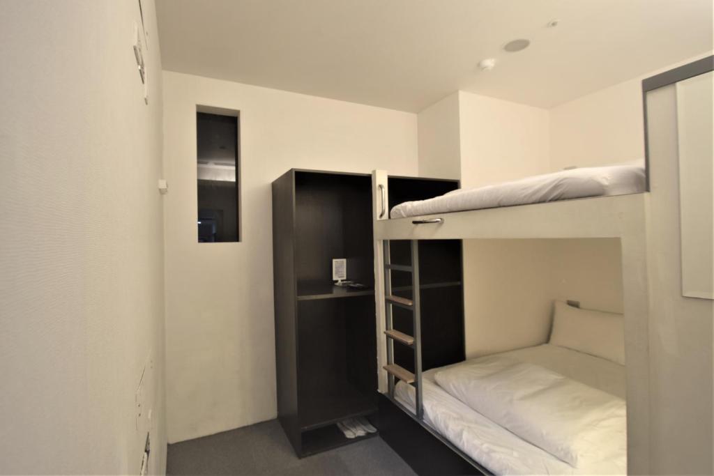 
a bedroom with a bed and a desk at Inn Cube - Ximen in Taipei
