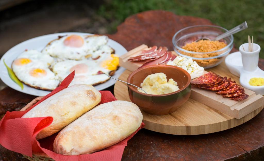 una mesa con huevos, pan y otros productos de desayuno en Domaćinstvo Filipović, en Rakovica