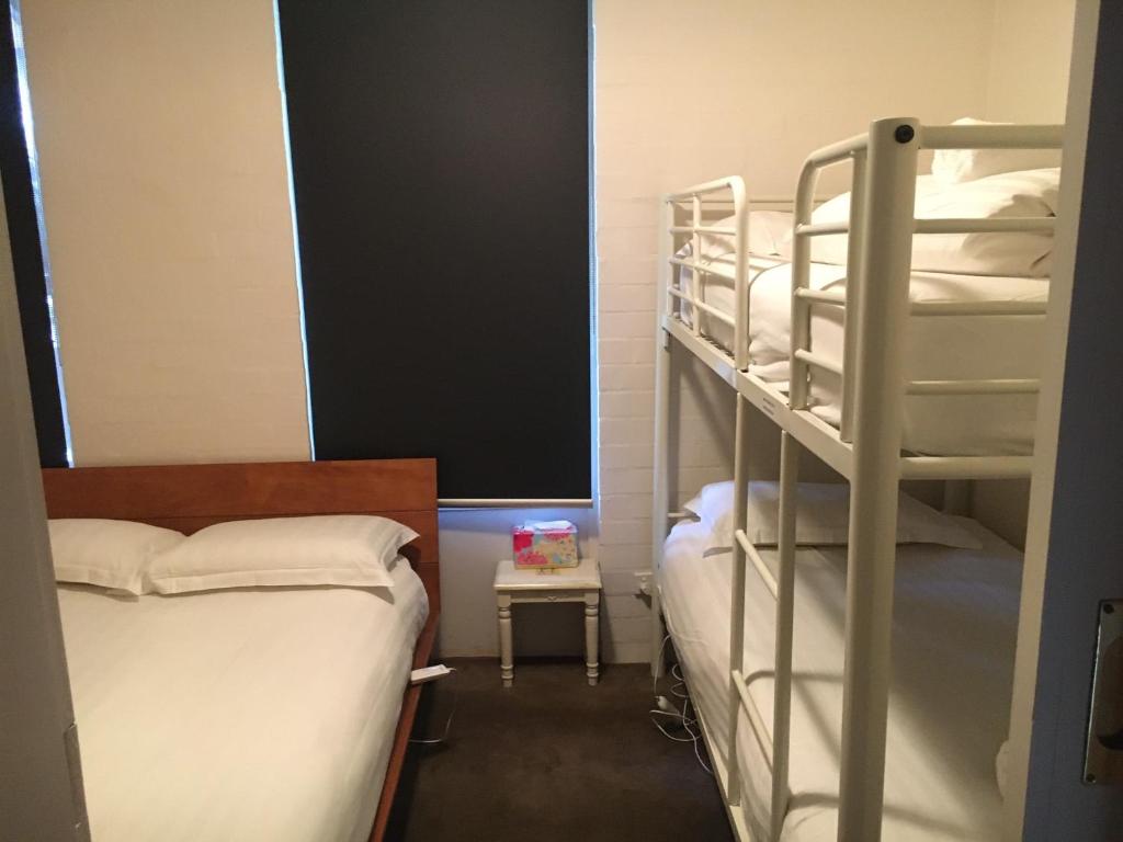 a dorm room with two bunk beds and a blackboard at Hima 8 in Mount Buller