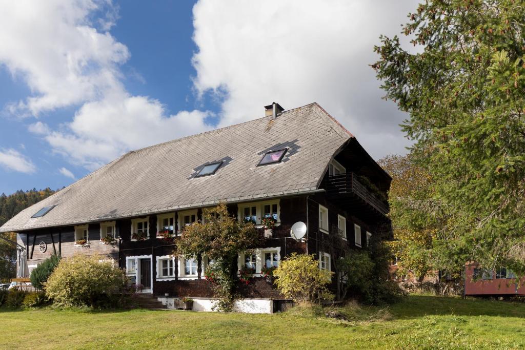 une grande maison noire avec un toit en gambrel dans l'établissement WÄLDER: Quartier Dachsberg, à Dachsberg im Schwarzwald