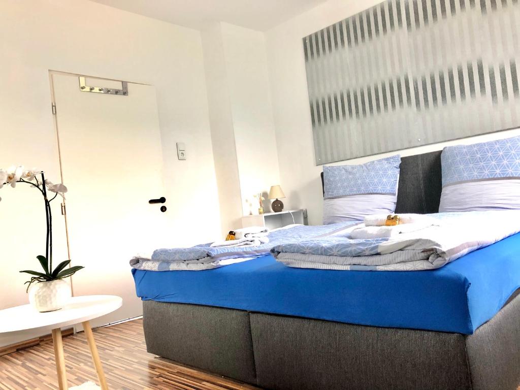 1 dormitorio con 1 cama grande con sábanas azules en #WORLD Privat Wohnung en Schkeuditz