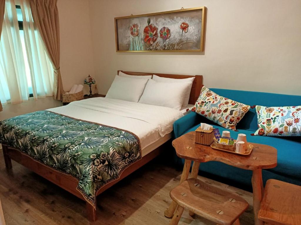a hotel room with a bed and a couch at Jilufugan B&amp;B in Taimali