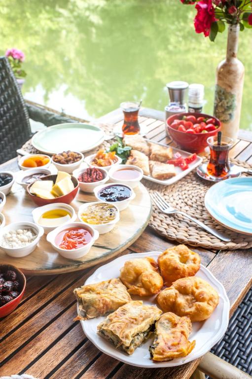 a wooden table with plates of food on it at Park Mandalin Hotel - Adult only in Ağva