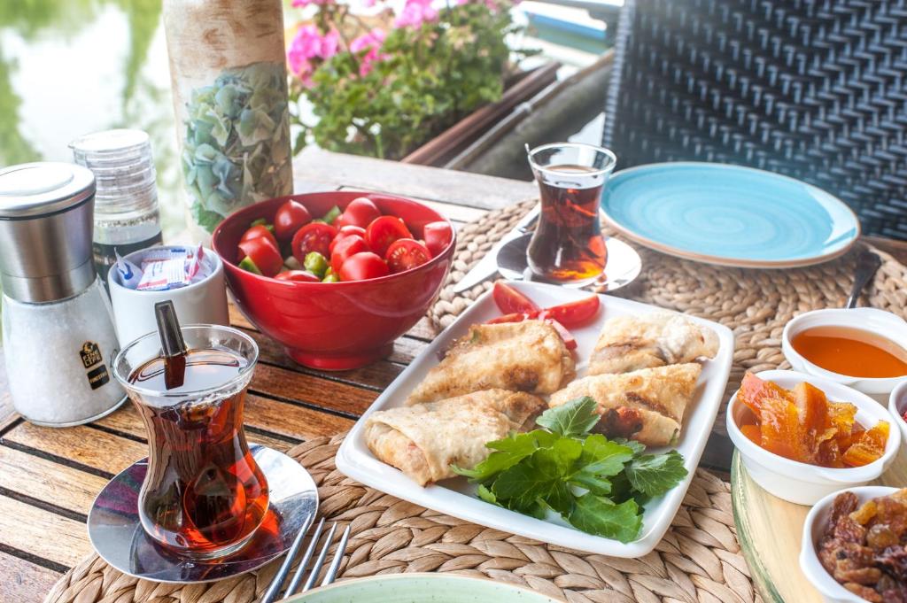 a table with a plate of food and a bowl of fruit at Park Mandalin Hotel - Adult only in Ağva
