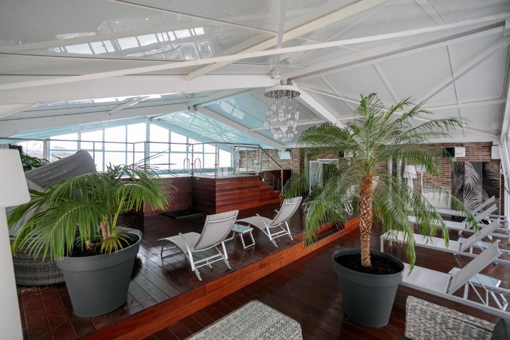 a room with chairs and potted plants in a building at Hôtel Spunta Di Mare in Ajaccio