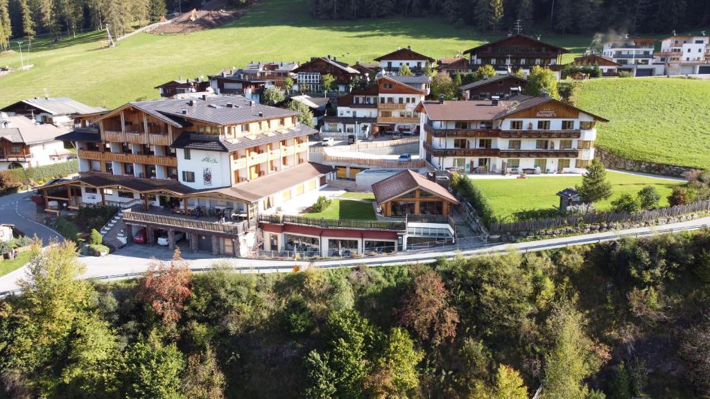 un grupo de casas en una colina con una carretera en Biovita Hotel Alpi, en Sesto