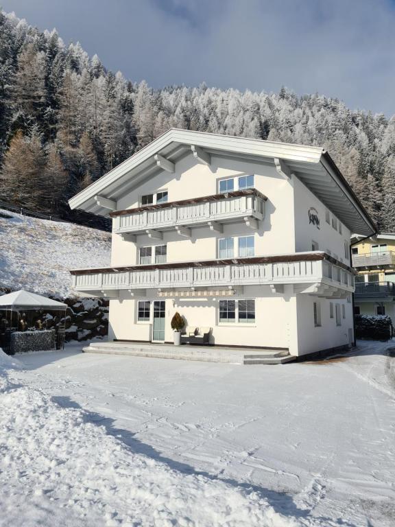 una casa bianca con la neve per terra di Appartement Skorpion a Sölden