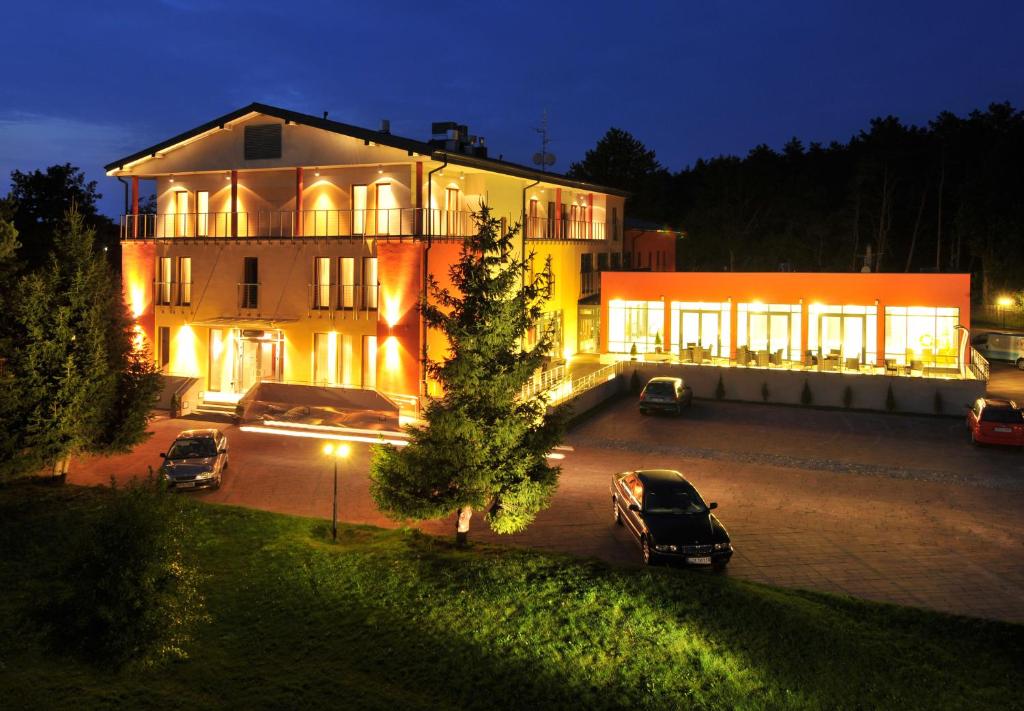 een groot huis met auto's geparkeerd op een parkeerplaats bij Centrum Wypoczynkowo-Konferencyjne Solaris in Łazy