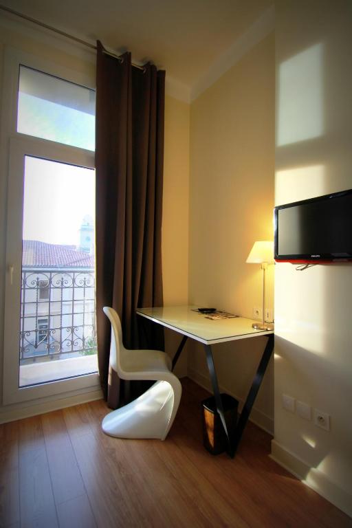 a room with a desk and a chair and a window at Hôtel Amirauté in Toulon