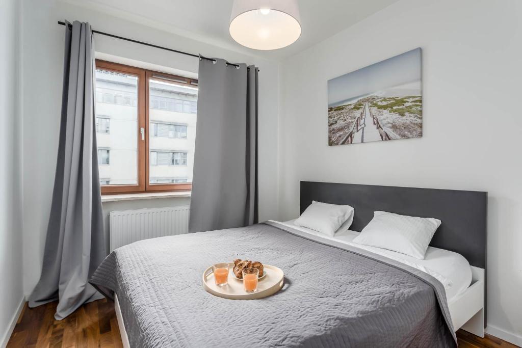 a bedroom with a bed with a tray of shoes on it at Chill Apartments Airport Residence in Warsaw