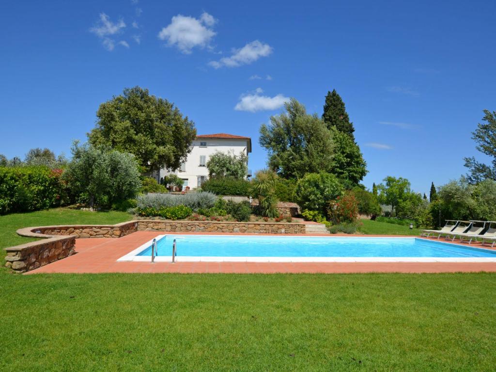 een zwembad in een tuin met een huis op de achtergrond bij Villa di Vinci by Interhome in Cerreto Guidi
