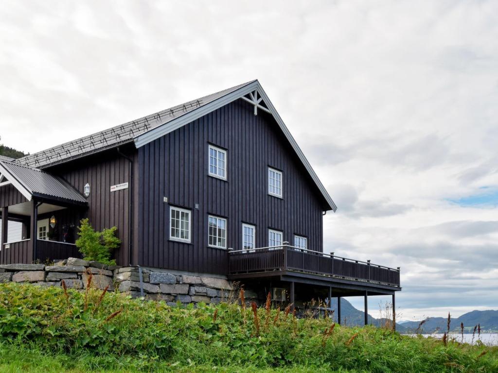 una casa negra en una colina con terraza en Chalet Bøgeilen - FJM303 by Interhome, en Heggem