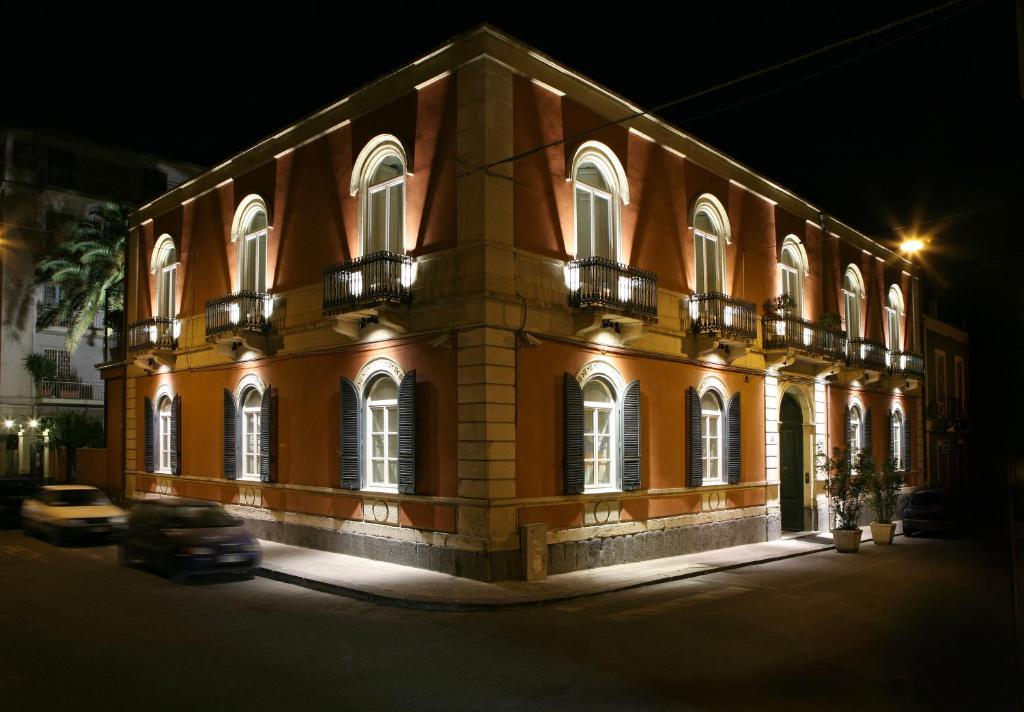 un edificio con un'auto parcheggiata di fronte di Liberty Hotel a Catania