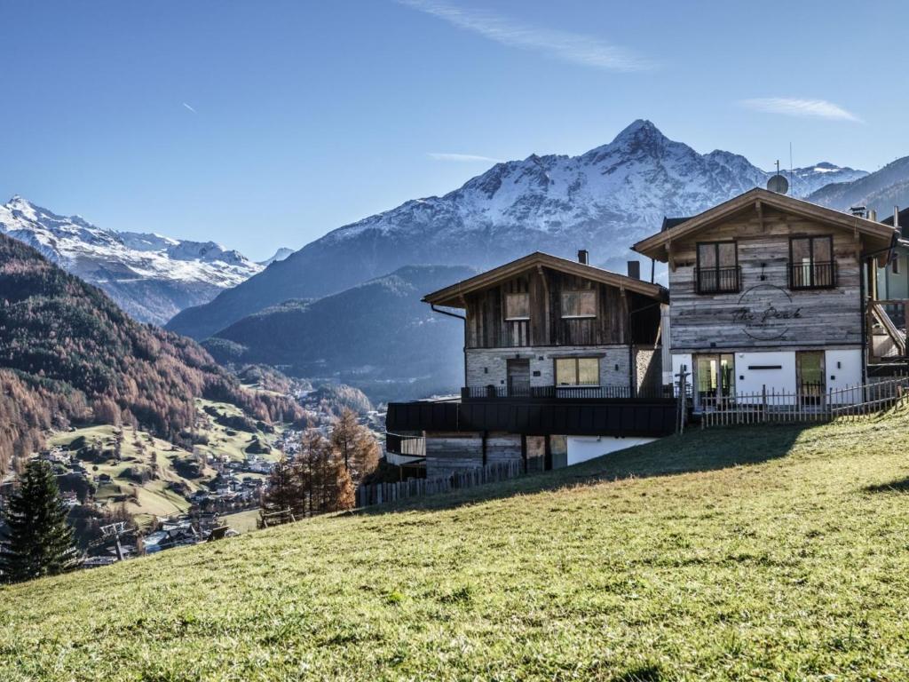 a house on a hill with mountains in the background at Holiday Home The PEAK-4 by Interhome in Sölden