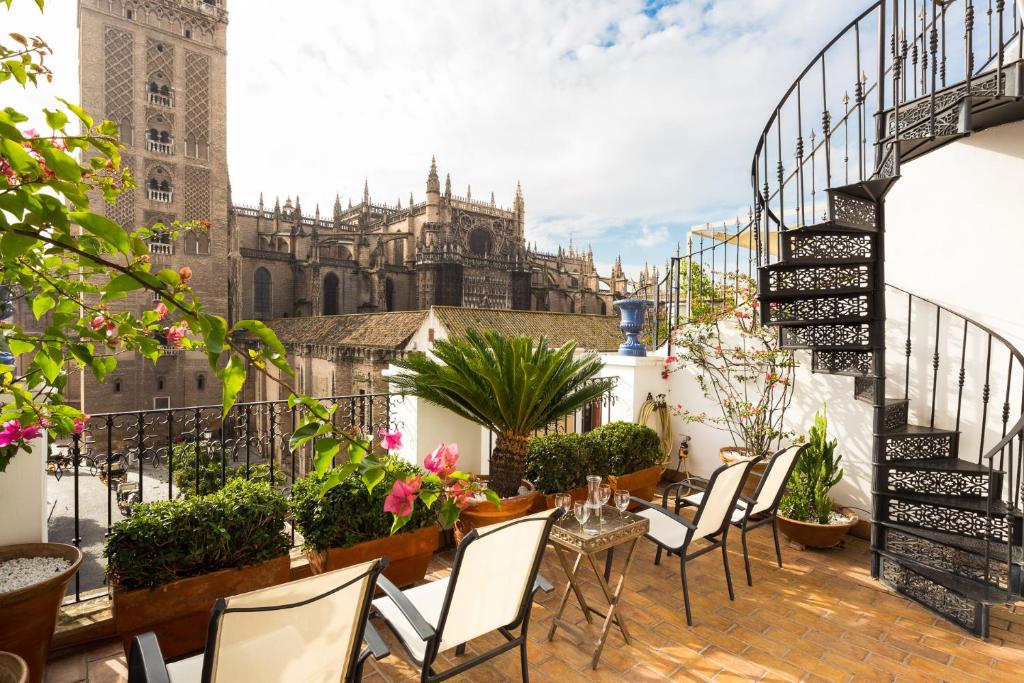 a balcony with chairs and a view of a cathedral at Veoapartment Casa Catedral in Seville