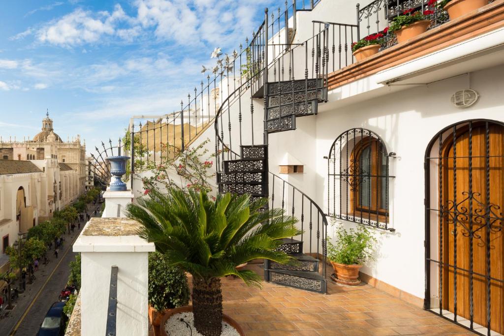 ulica z białymi budynkami i palmą w obiekcie Veoapartment Casa Catedral w Sewilli