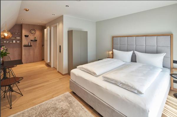 a bedroom with a large white bed and a desk at Kaiser 4 in Norderney