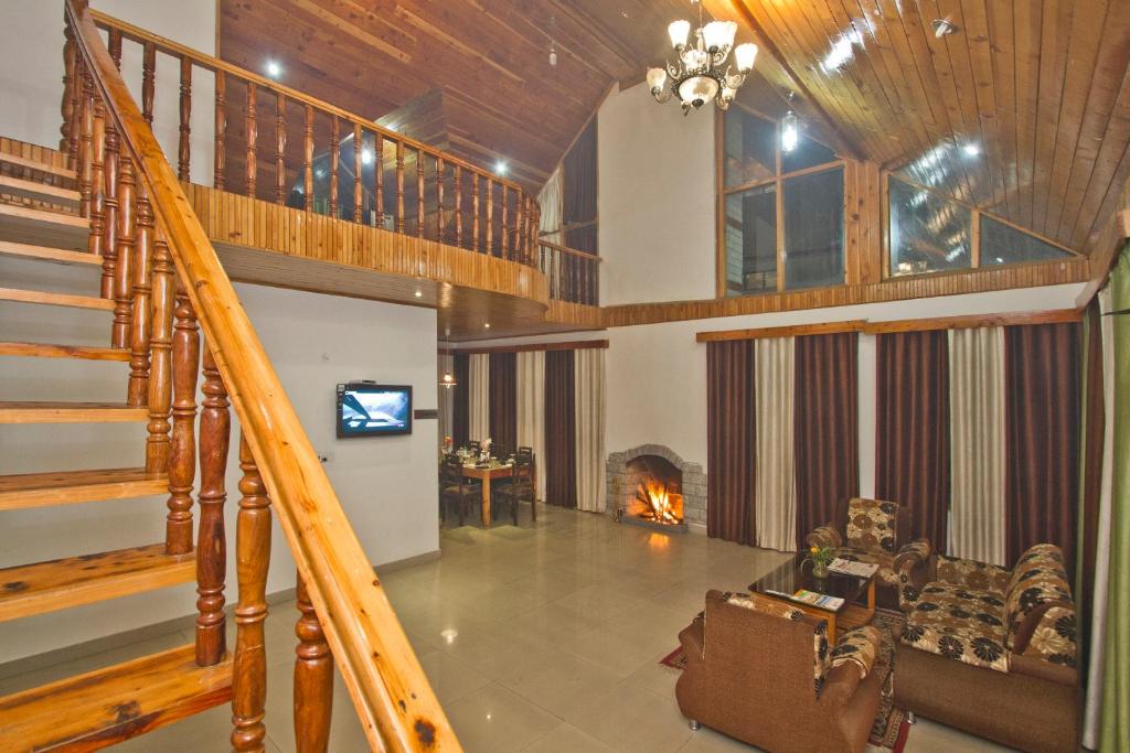 a living room with a staircase and a fireplace at The Cedar Cottages & Independent Villa & Kitchenette Fireplace Tandoor & BBQ in Manāli