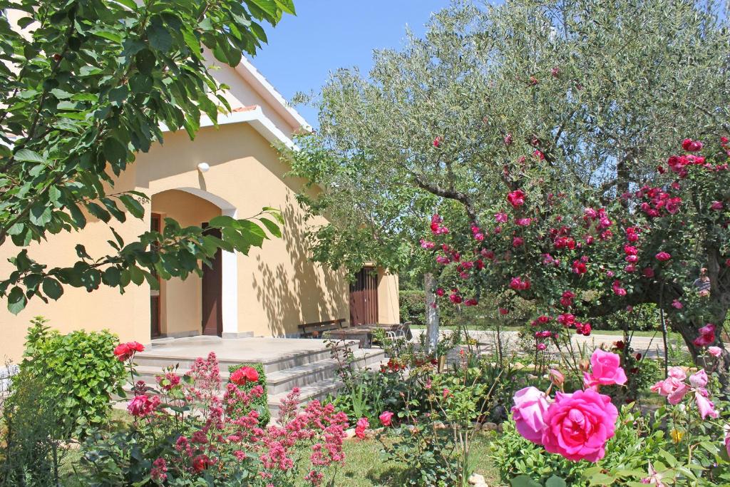 una casa con flores rosas en el patio en Rooms Teklić, en Rovinj