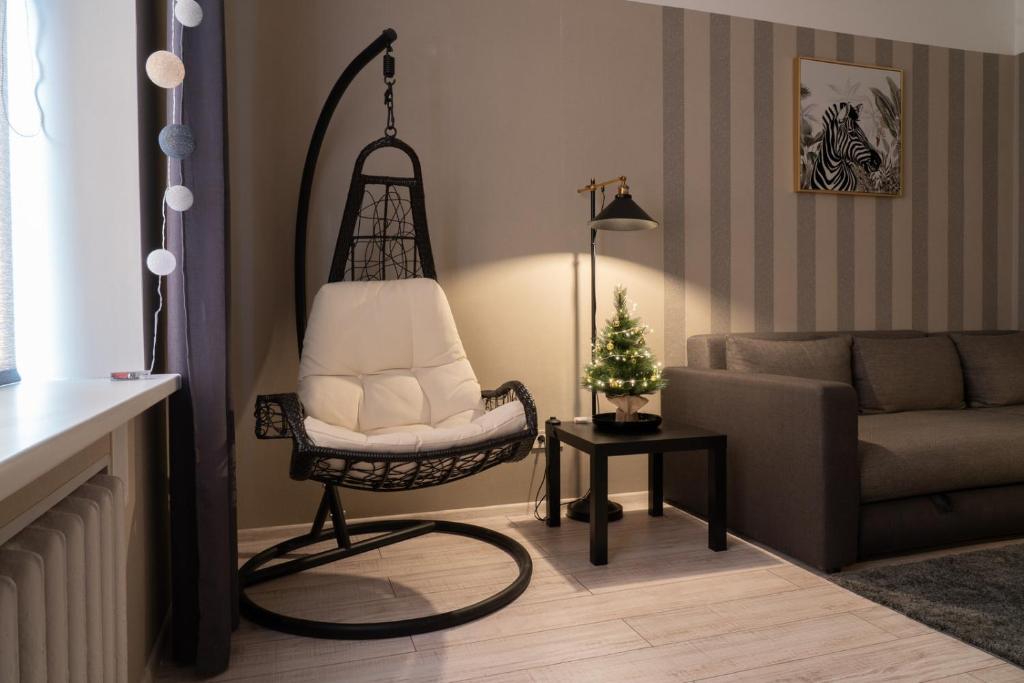 a living room with a chair and a couch at ALFA apartment in Riga