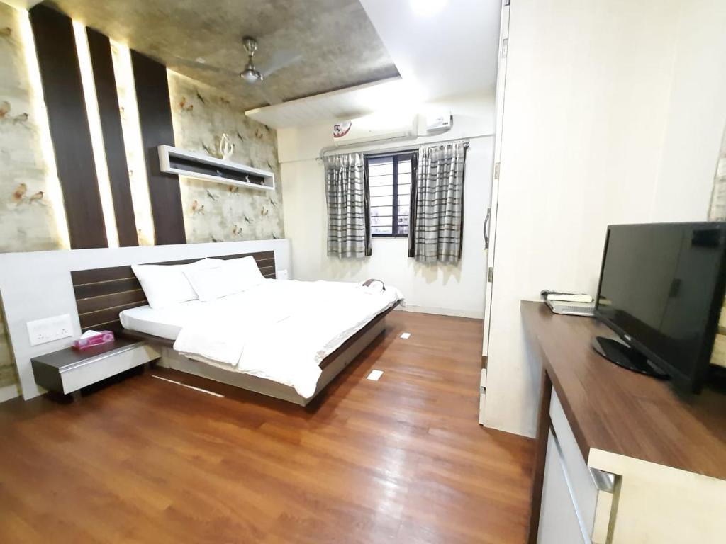 a bedroom with a bed and a flat screen tv at MajickMoments Hadapsar-Magarpatta Pune in Pune