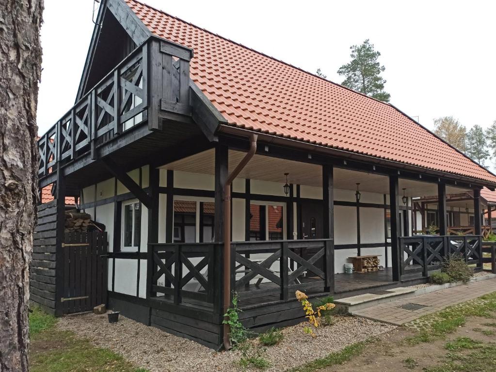a large house with a red roof at dom całoroczny na Kaszubach Nietoperek, prywatna balia, bania ruska, prywatna sauna in Załakowo