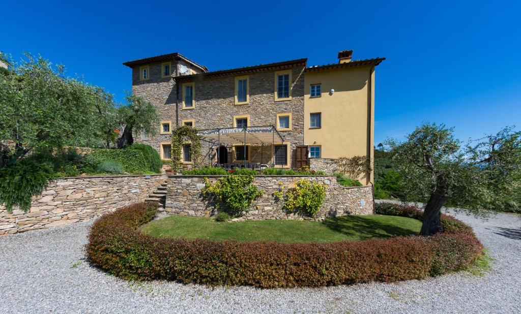 una gran casa de piedra con una pared de piedra en Luxury 6-bed Tuscan Villa near Lucca, en Castelvecchio