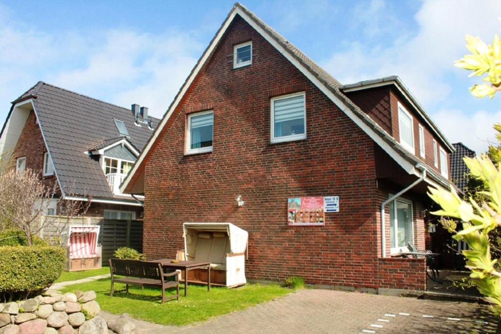 a brick house with a table in the yard at Modern Apartment in Westerland-Sylt, 50 sqm, close to beaches in Westerland (Sylt)