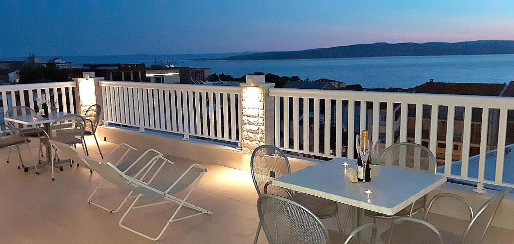 un patio con mesas y sillas en el balcón en Apartments Villa Bonaca, en Baška Voda