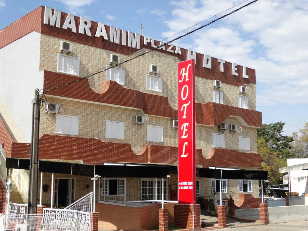 a building with a red sign in front of it at Maranim Plaza Hotel in Amparo