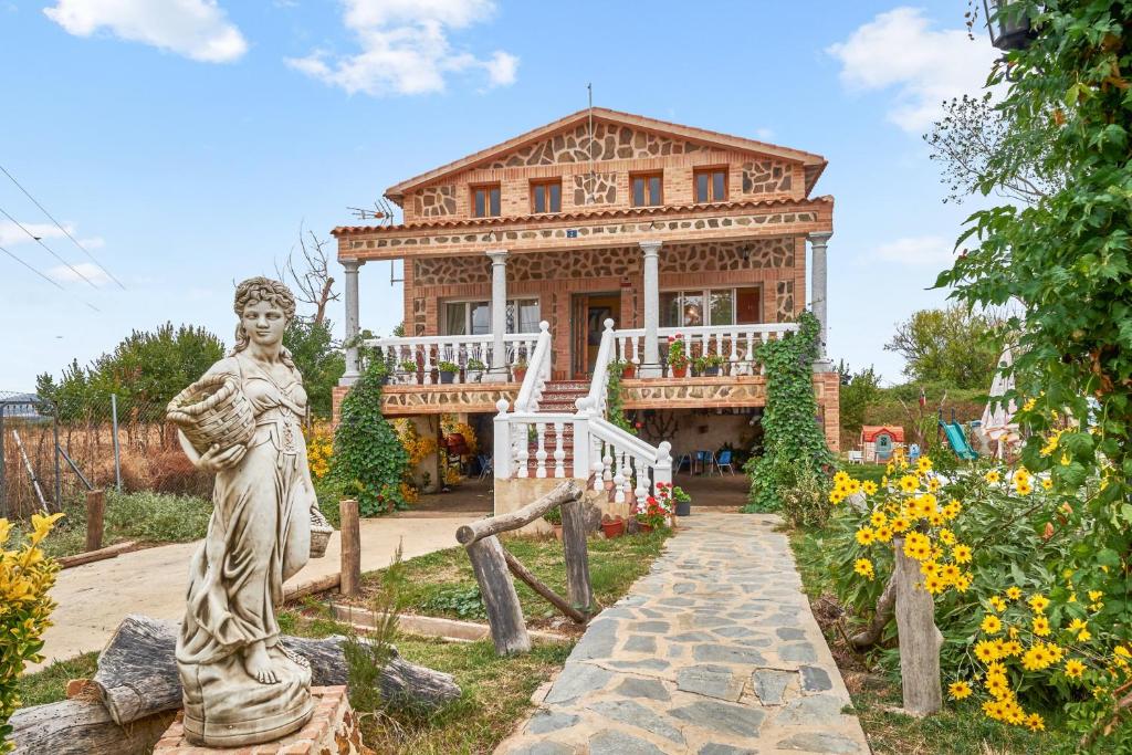 a statue of a woman in front of a house at 3 bedrooms villa with city view private pool and jacuzzi at Porzuna in Porzuna