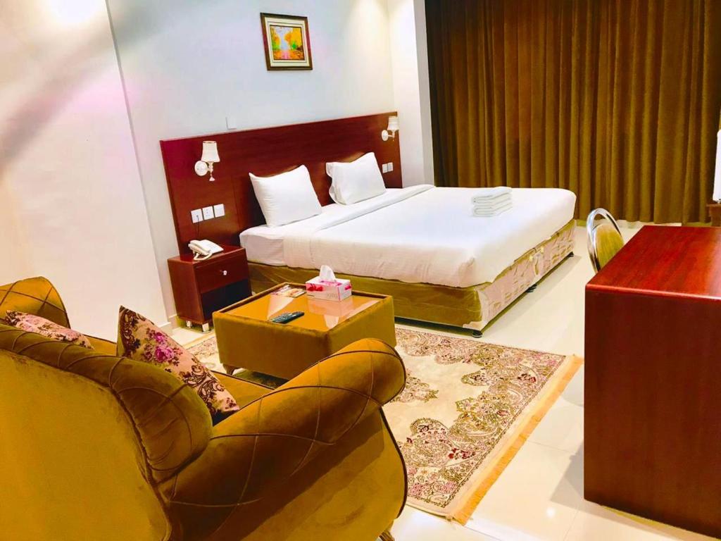 ALJAWHARA INN HOTEL في سيب: غرفه فندقيه بسرير واريكه