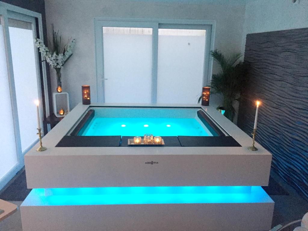 a swimming pool with blue lights in a living room at One bedroom house with jacuzzi enclosed garden and wifi at Tournai in Tournai