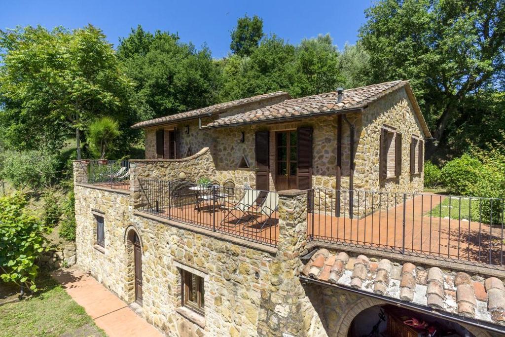 a stone house with a balcony on top of it at Charming Apartment in Montepulciano 45m² with shared pool in Montepulciano