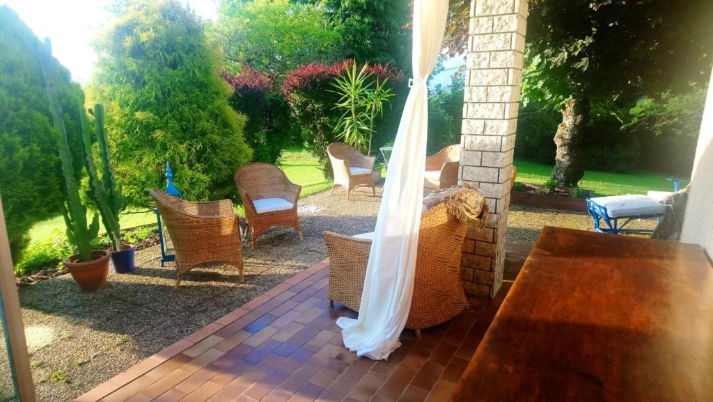 - une terrasse couverte avec une table et des chaises en bois dans l'établissement Maison de 2 chambres avec jardin clos et wifi a Reignier Esery, à Ésery