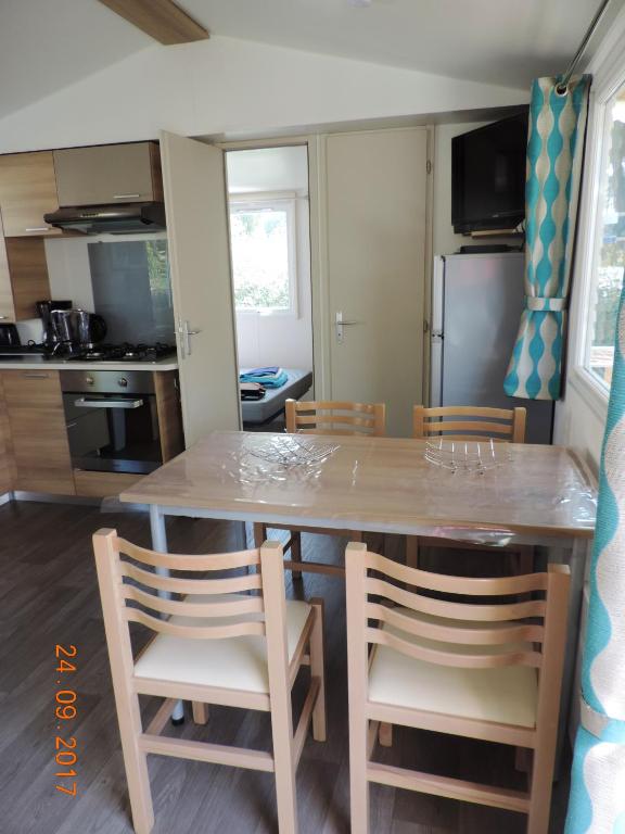 une cuisine avec une grande table et des chaises en bois dans l'établissement Bungalow Confort Gastes Jacuzzi, à Gastes