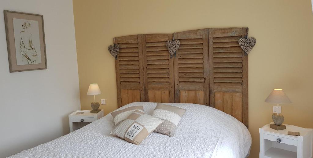 a bedroom with a large bed with white pillows at La maison Virginie logements de 1 à 5 pers chaleureux centre, parking, linge, wifi, proximité lac canal piscine in Montargis