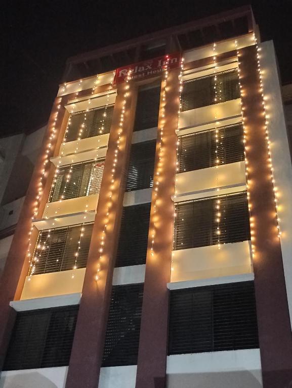 un edificio alto con luces encendidas por la noche en Hotel Relax Inn, en Nagpur