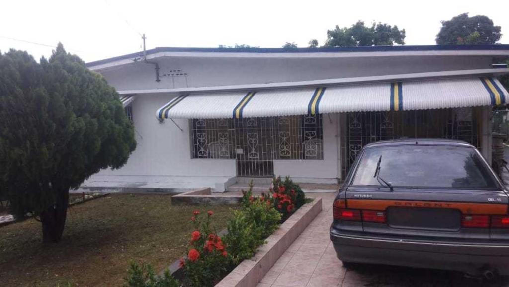 a car parked in front of a house at Lovely 4-Bed House in beautiful Portland in Buff Bay