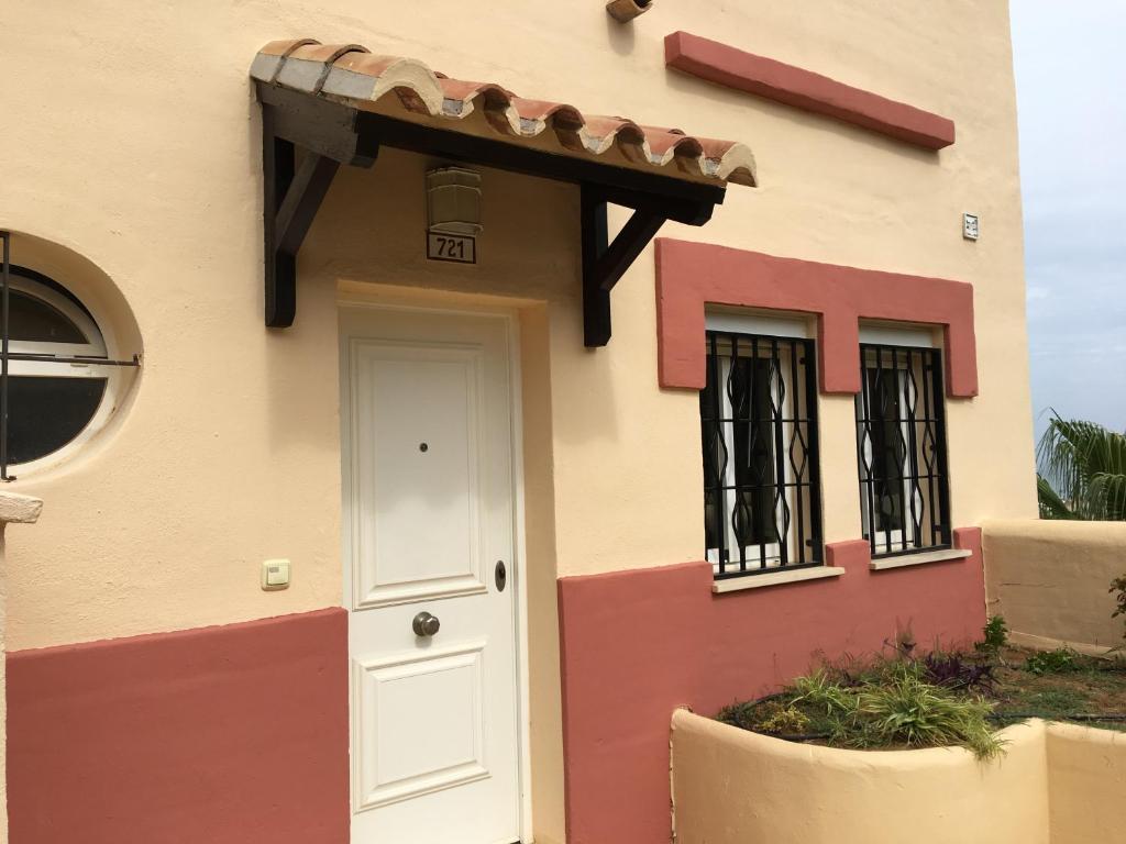 een huis met een witte deur en een veranda bij Penthouse sea views roof terrace communal pool in La Cala de Mijas