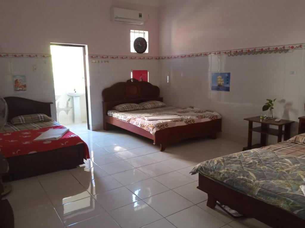 a bedroom with two beds and a window at Motel HAPPY in Bà Rịa