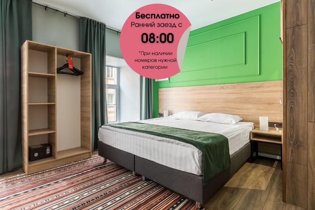 1 dormitorio con 1 cama con pared verde en Hotel Demut, en San Petersburgo