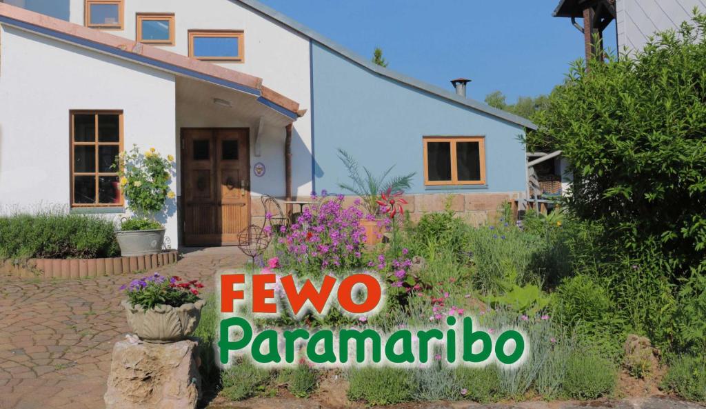 een huis met een bord voor een tuin bij FeWo Paramaribo in Witzenhausen