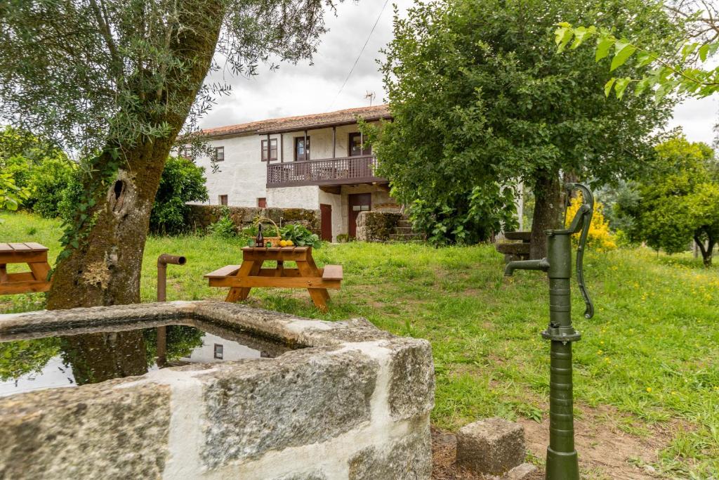 un parque con un árbol y una mesa y un edificio en Casa Lavoura em Requeixo, en Celorico de Basto