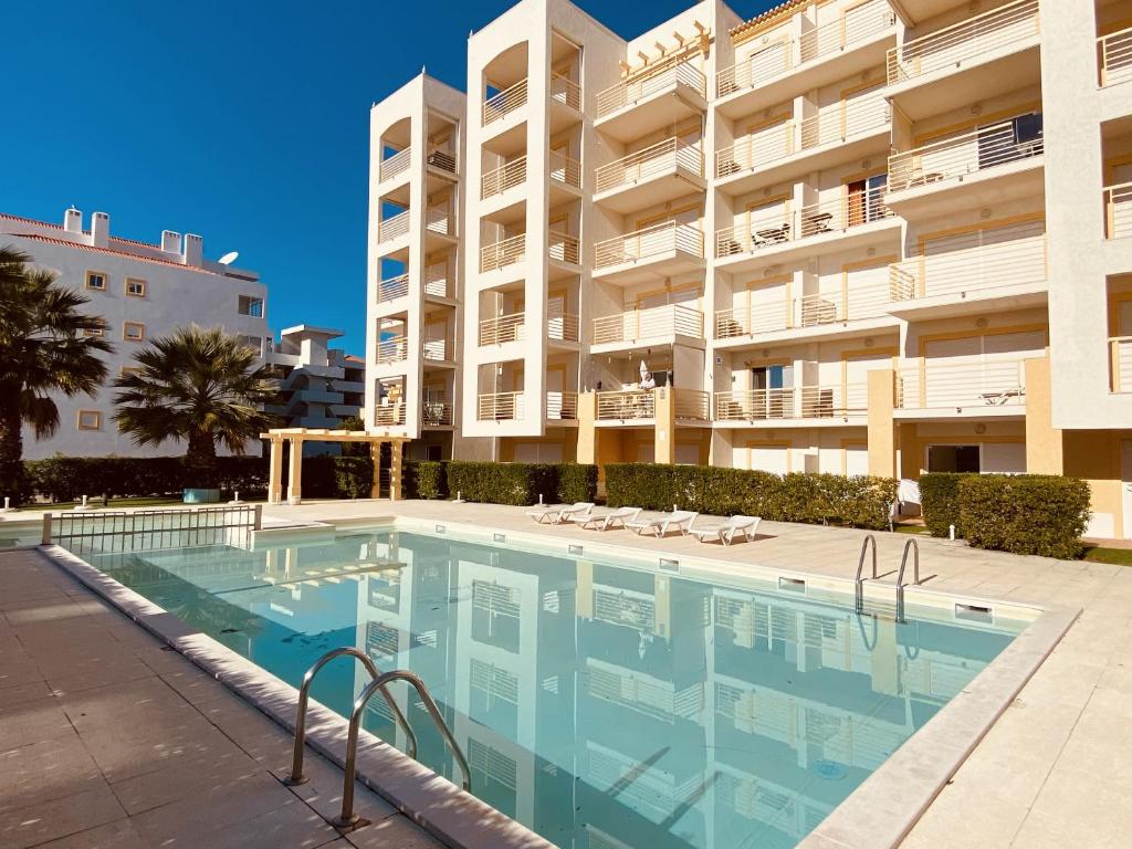 a swimming pool in front of a large apartment building at Vista - Shared Pool - 4 Guests - Albufeira in Albufeira