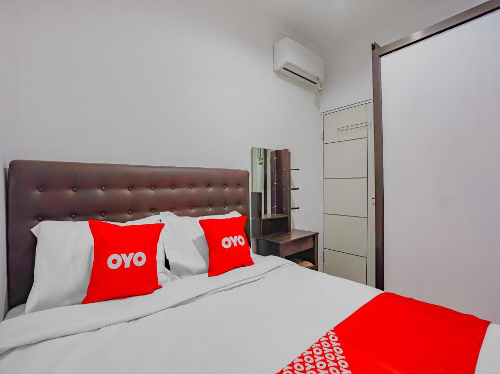 ein Schlafzimmer mit einem großen Bett mit roten Kissen in der Unterkunft SPOT ON 90110 A1 Pakis Argosari in Surabaya