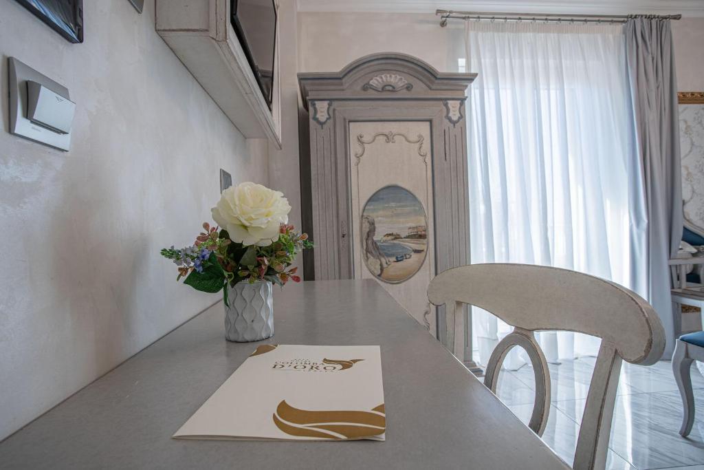 a table with a napkin and a vase of flowers on it at Hotel Colomba D'Oro in Tropea