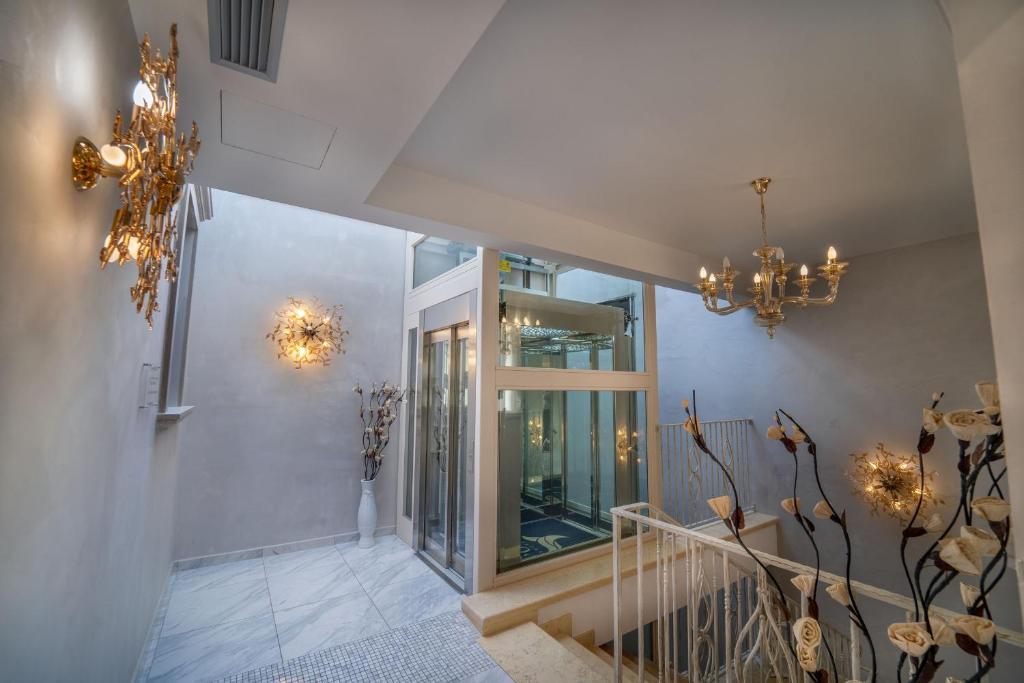 a hallway with chandeliers and a staircase in a house at Hotel Colomba D'Oro in Tropea