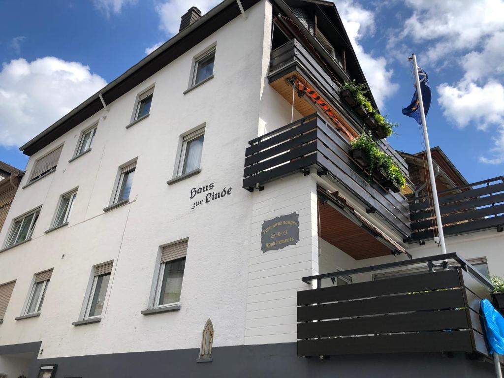 ein weißes Gebäude mit Schild für ein Hotel in der Unterkunft Ferienwohnungen Haus zur Linde in Cochem