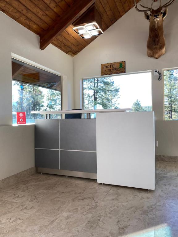 an empty lobby with a white counter and windows at Motel In The Pines in Munds Park